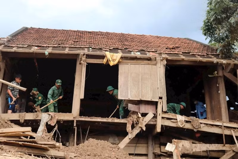 Officers and soldiers from My Ly Border Guard Station, Nghe An Province, help local people clean and repair their houses after floods. (Photo: Viet Lam)