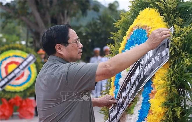 PM Pham Minh Chinh pays floral tribute to the fallen Vietnamese volutary soldiers and experts at the event. (Photo: VNA)