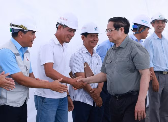 Prime Minister Pham Minh Chinh with engineers and workers constructing Phase 1 of the Chau Doc – Can Tho – Soc Trang expressway project. (Photo: VNA)