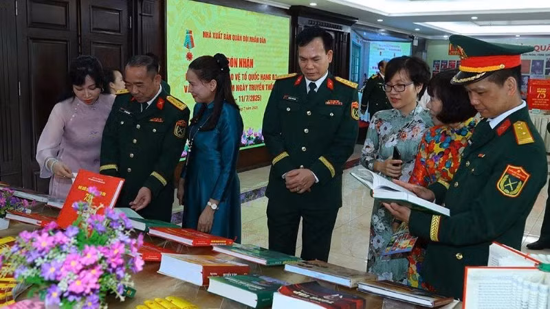 Visitors from within and outside the military learn about the publications on display at the People’s Army Publishing House’s book exhibition booth. (Photo: NDO)