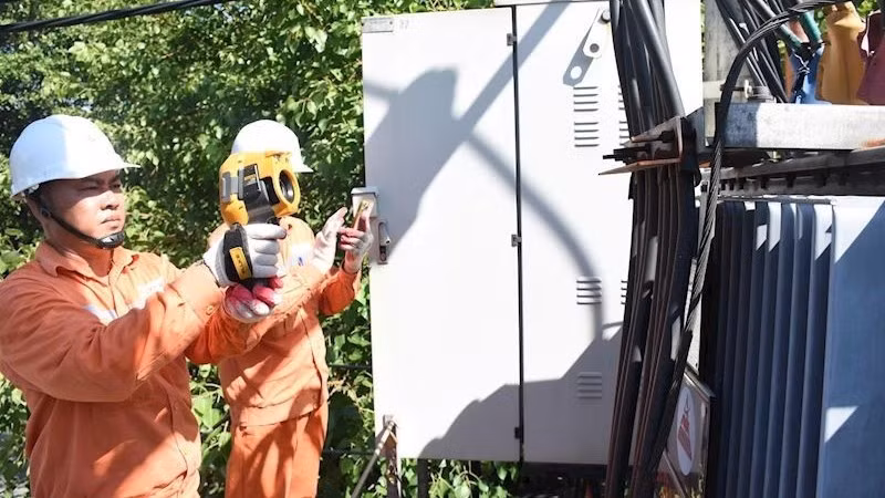 Staff from Ha Noi Power Corporation (EVNHANOI) inspect electrical equipment. (Photo: NDO)
