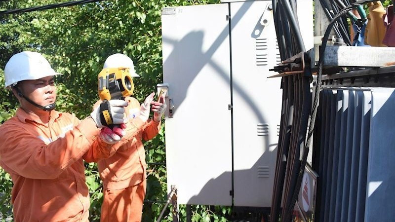 Staff from Ha Noi Power Corporation (EVNHANOI) inspect electrical equipment. (Photo: NDO)