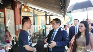 PM Pham Minh Chinh (centre) and his spouse visit the family of Vo Ba Luan - the owner of a restaurant in Nice. (Photo: VNA)