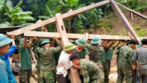 Officers and soldiers of the Tram Tau district armed forces help a poor household in Hat Luu commune build a new house. (Photo: thanhtra)