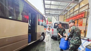 Military medical staff load Chloramin B – a water disinfectant chemical – onto a truck.
