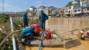 Militia forces operate water pumps to clean streets and schools in Thuc Phan Ward, Cao Bang Province. (Photo: Minh Tuan)