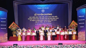 Secretary of Ha Noi Party Committee Nguyen Duy Ngoc and Minister of Education and Training Nguyen Kim Son present the Labour Orders, awarded by the State President, to outstanding collectives and individuals. (Photo: Thanh Tung)