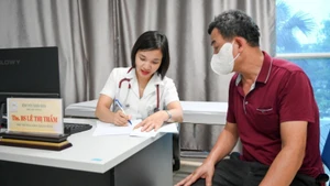A doctor examines a patient at the Outpatient Department of Thanh Nhan Hospital, Ha Noi. (Photo: The Dai)