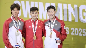 Swimmer Pham Thanh Bao (centre) of Viet Nam successfully defends his SEA Games title in the men’s 200m breaststroke, touching home first in the final with a time of 2 minutes 12.81 seconds. (Photo: VNA)