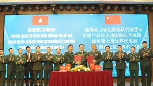 The heads of the two delegations sign the minutes of the talks on December 30. (Photo: VNA)