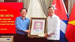 Deputy Prime Minister Ho Quoc Dung presents a portrait of President Ho Chi Minh to Ambassador Le Quang Long and staff of the Embassy. (Photo: Viet Nam Embassy in Cuba)