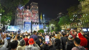 Large numbers of residents and visitors gather at Ha Noi Cathedral on Christmas Eve. (Photo: THE DAI)