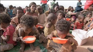 Two malnourished children drink milk from their plastic bowls at the Kebribeyah refugee camp in eastern Ethiopia (Photo: AFP/VNA)