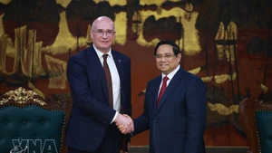 Prime Minister Pham Minh Chinh (R) welcomes TASS Director General Andrey Kondrashov (Photo: VNA) 