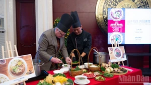 International friends experience how a bowl of pho is prepared. (Photo: NDO)