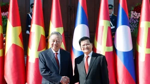General Secretary of the Lao People’s Revolutionary Party (LPRP) Central Committee and President of Laos Thongloun Sisoulith (Right) welcomes General Secretary of the Communist Party of Viet Nam (CPV) Central Committee To Lam during his state visit to Laos. (Photo: VNA)