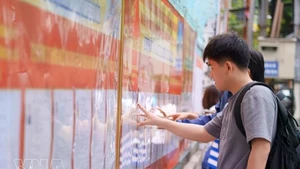 Students at the University of Technology and Education - The University of Danang study the list of candidates posted at the university. (Photo: VNA)