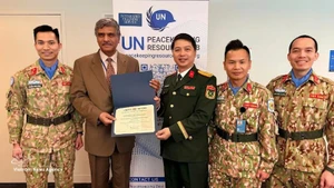 Harinder Sood (second, left), head of the Integrated Training Service under the UN Department of Peace Operations, presents the certificate recognising the UN Staff Officers Course of Viet Nam as meeting the UN's pre-deployment training standards. (Photo: Viet Nam Department of Peacekeeping Operations)