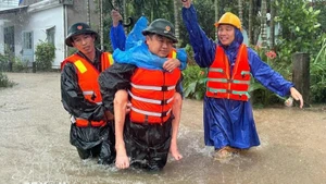 Military forces take a resident from a flooded area. (Photo: VNA)