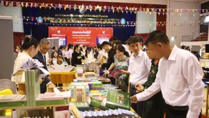 Delegates visit the book display booth of the Vietnamese Embassy in Laos. (Photo: VNA)