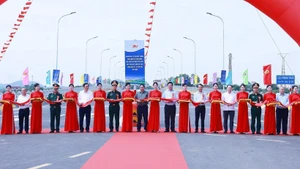 Prime Minister Pham Minh Chinh and delegates perform the ribbon-cutting ceremony to inaugurate the new Phong Chau bridge on National Highway 32C. (Photo: VNA)