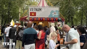 Visitors line up to enjoy "Pho (Vietnamese noodle soup) at the festival. (Photo: VNA)
