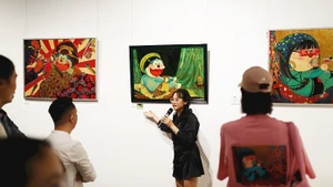 Phan Tu Tran presents her works to exhibition visitors (Photo courtesy of the artist)