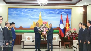 Ambassador Nguyen Minh Tam presents Party General Secretary To Lam's flowers to the LPRP Central Committee's External Relations Commission to congratulate on the LPRP's 71st founding anniversary. (Photo: VNA)
