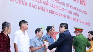 PM Pham Minh Chinh presents the announcements of martyrs' DNA testing results to representatives of families at the conference on July 25. (Photo: VNA)