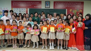 Ngo Phuong Ly presents Vietnamese books and storybooks to the children.