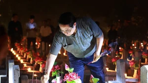 Prime Minister Pham Minh Chinh lights candles and incense to pay tribute to heroic martyrs at Truong Son National Martyrs' Cemetery. (Photo: VNA)