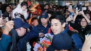 Striker Dinh Bac is embraced by fans. (Photo: VNA)