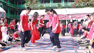 Schoolchildren join a bamboo pole dance at the festival