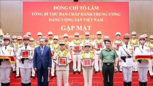 Party General Secretary To Lam and Minister of Public Security Gen. Luong Tam Quang present gifts to outstanding individuals from the People’s Public Security Force and grassroots-level security units, at the meeting. (Photo: VNA)