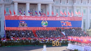 A military parade and march held to celebrate the 50th National Day of the Lao People’s Democratic Republic. (Photo: VNA)