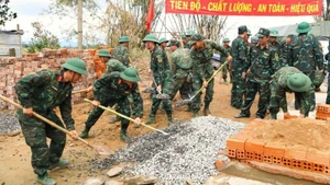 Soldiers of Military Region 5 work together to rebuild homes for residents affected by floods in Dak Lak Province. (Photo: Van Vien)