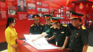 Delegation of officers and soldiers of Division 3 (Military Region 1) experience reading e-books at the exhibition. (Photo: Nhan Dan Newspaper)