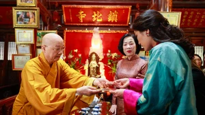 Most Venerable Thich Thanh Nha, Abbot of Tran Quoc Pagoda, presents a Bodhi leaf to Nguyen Thi Minh Nguyet, spouse of State President Luong Cuong, and Bhutanese Queen Jetsun Pema Wangchuck. (Photo: NDO)