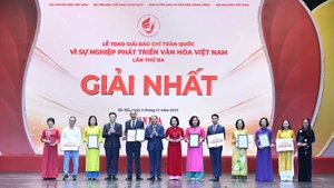 Deputy Prime Minister Mai Van Chinh and Minister of Culture, Sports and Tourism Nguyen Van Hung present first prizes to the winners. (Photo: NDO)