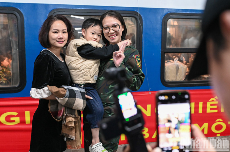 Female soldiers took souvenir photos with relatives before the train departed.