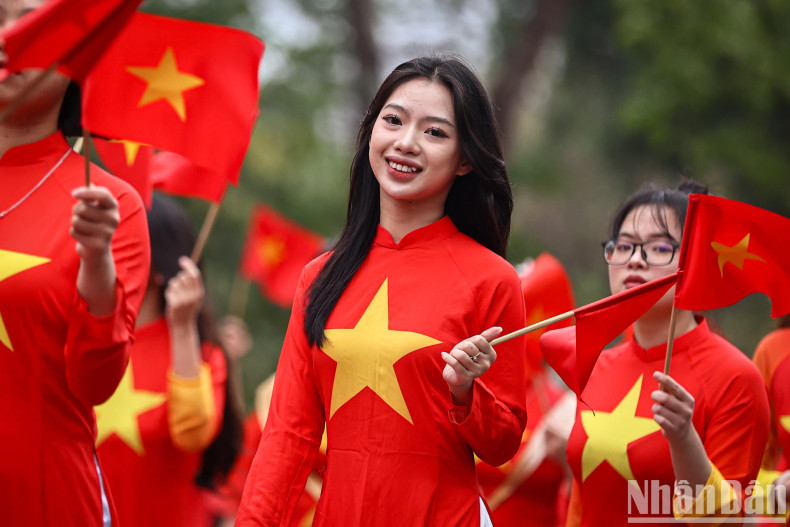 Young women in Ao Dai with the national flag. Young women in Ao Dai with the national flag.