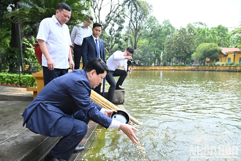 State President Luong Cuong feeds the fish at President Ho Chi Minh’s fish pond.