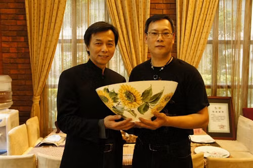 Painter Hong Duc Thanh (R) is pictured with his artwork painted on one of the world's thinnest ceramic bowls, crafted by Taiwanese artisan Huang Cheng-nan. (Photo courtesy of the artist)