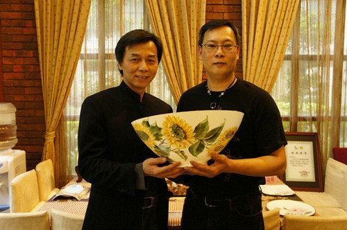 Painter Hong Duc Thanh (R) is pictured with his artwork painted on one of the world's thinnest ceramic bowls, crafted by Taiwanese artisan Huang Cheng-nan. (Photo courtesy of the artist) Painter Hong Duc Thanh (R) is pictured with his artwork painted on one of the world's thinnest ceramic bowls, crafted by Taiwanese artisan Huang Cheng-nan. (Photo courtesy of the artist)
