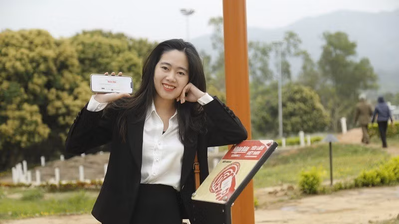 Mai Hai Yen shares a moment accessing destination information at the NFC chip-integrated board under the "Love Vietnam So Much" project by Nhan Dan Newspaper.