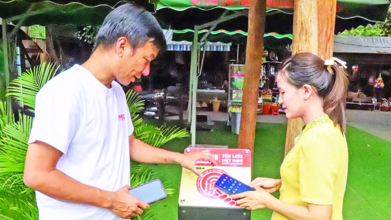 A visitor scans an NFC-enabled board from the “Love Vietnam So Much” project at the Buon Don Suspension Bridge Tourism Centre, Dak Lak Province. (Photo: KIM BAO)