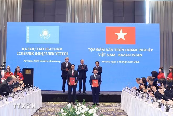 Party General Secretary Lam, Deputy PM of Kazakhstan Kosherbayev, and Vietnamese Deputy Prime Minister and Foreign Minister Bui Thanh Son witness the exchange of a business franchise agreement between Vietjet Air and Qazaq Air. (Photo: VNA)