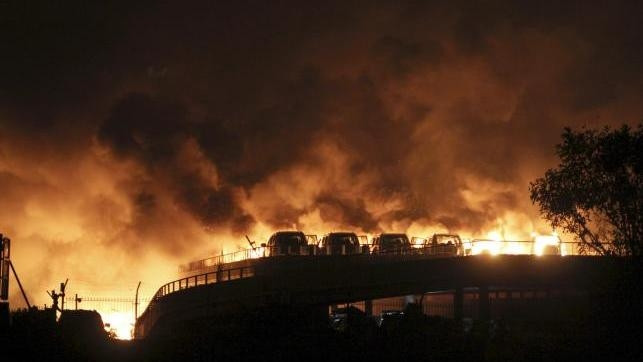 Vehicles are seen burning after blasts at Binhai new district in Tianjin municipality, China, August 13, 2015.