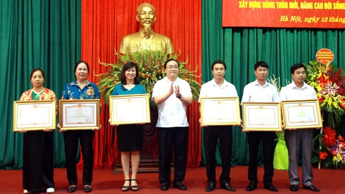 Hanoi Party Secretary Hoang Trung Hai presents certificates of merit from the PM to outstanding collectives and individuals. (Credit: hanoimoi.com.vn)