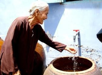 Heroic mother Doan Thi The of Can Thanh town, Can Gio district, is happy she now has clean water to use.